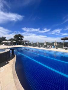 伊比乌纳Paraty Hotel Fazenda & Spa的一个带遮阳伞的大型蓝色游泳池