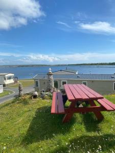 米勒姆Port Haverigg Holiday Village的坐在水边的草上野餐桌