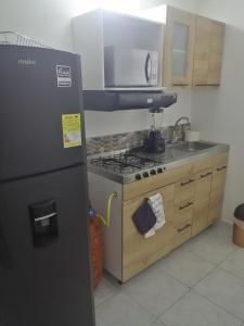 麦德林San Diego aparta estudios的厨房配有冰箱和炉灶。 顶部烤箱