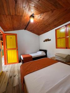 贾丁Hospedaje Campestre El Rancho de Jero的一间卧室设有两张床和木制天花板
