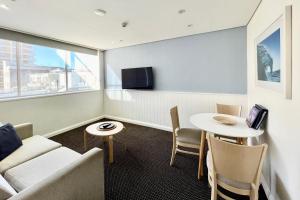 悉尼库吉金沙大酒店和公寓的客厅配有沙发和桌子