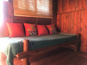 康考迪亚Campo Verde的红色和绿色枕头的宿舍间内的一张床位