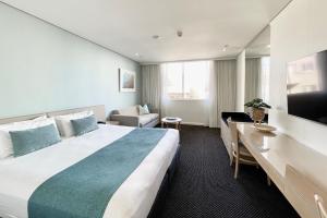 悉尼库吉金沙大酒店和公寓的酒店客房设有一张大床和一台电视。