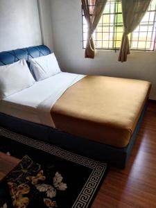 Kampong Telokkhairul homestay taman tengiri seberang jaya的一张位于带2扇窗户的房间的床