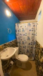 埃尔扎伊诺WAYANAY TAYRONA ECO HOSTEL的浴室配有水槽、卫生间和浴帘