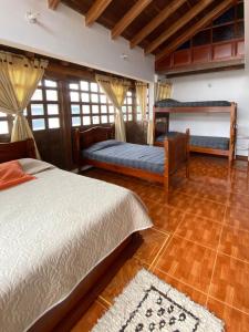 莱瓦镇Chez Alicia Hostal的一间卧室设有两张床,铺有木地板