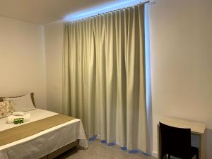 塞尔苏拉穆斯州长镇Pousada Divino Oleiro - Gov. Celso Ramos的一间卧室配有床和带窗帘的窗户