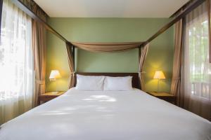 班科隆姆章盛泰乐达叻府临海别墅及度假村的一间卧室配有一张带两盏灯的大型白色床。