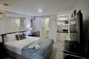 佩里吉安比奇亥努沙男性专用海滩度假酒店的一间带大床的卧室和一间厨房