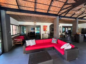 蔻立Coral Beach Pool Villa Khao Lak - SHA Extra Plus的一间客厅,客厅里设有红色沙发