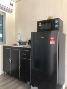 马六甲Laman Cottage @ Brisu, Melaka的厨房配有冰箱上方的微波炉