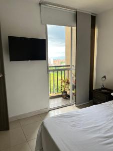 佩雷拉APARTAMENTO CONDINA PEREIRA的一间卧室设有一张床,享有阳台的景色
