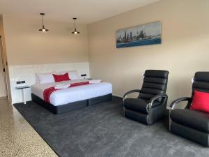马塔卡纳马塔卡纳汽车旅馆 的一间卧室配有一张床和两把椅子