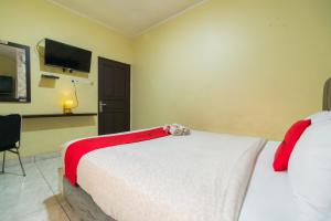 雅加达RedDoorz near Tomang 2的酒店客房,配有一张带泰迪熊的床