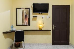 雅加达RedDoorz near Tomang 2的客房设有一张桌子、一台电视和一扇门