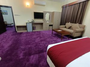 马斯喀特ROYAL HOTEL的酒店客房配有床、沙发和电视。