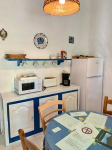 埃尔乔罗La Casita Blanca- La Almona Chica的厨房配有桌子、微波炉和冰箱。