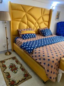 拉各斯The Residence Golden Tulip 2 Bedroom Apartment, Amuwo Lagos, Nigeria的一间卧室配有一张带黄色床头板的大床