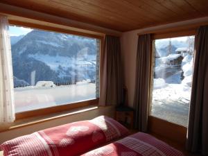 CumbelsDado Casanova的一间卧室设有窗户,享有雪覆盖的山脉美景