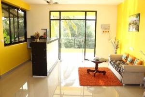 SAHAY VILLA RESORT的客厅设有黄色的墙壁、一张沙发和一张桌子