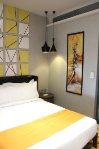 新德里新德里国际机场T3航站楼智选假日酒店的一间卧室配有一张床和两个吊灯