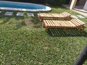 巴拉那Rinacasaquinchoypile的两个木凳坐在游泳池旁