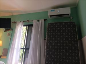巴拉那Rinacasaquinchoypile的一间卧室设有窗户、窗帘和空调