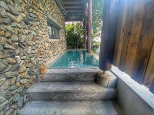汤泽町Heidi Guest House的一座游泳池,位于石墙和楼梯旁