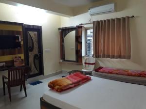 Murshidābādhotel sagnik的一间卧室配有一张床、一张书桌和一面镜子