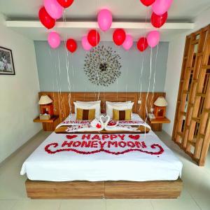 勒吉安The Sakaye Villas & Spa的一间卧室,配有一张带气球的床,并拥有快乐的和谐月亮