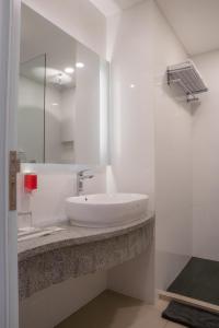雅加达Grand G7 Hotel Pasar baru的白色的浴室设有水槽和镜子