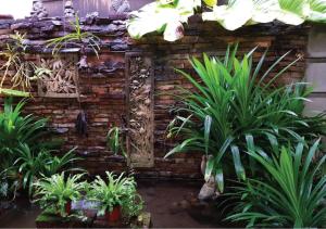 Ban Nua KhlongPakin house的砖墙前种有植物的花园