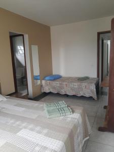 里约热内卢Buganville House Cabo Frio的一间卧室配有两张床和镜子