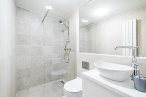 比得哥什E-Stay Noclegi w Bydgoszczy的白色的浴室设有水槽和淋浴。