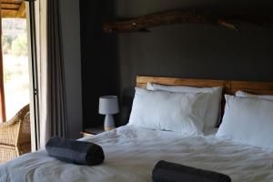 贝拉贝拉Waterberg Game Lodge的卧室配有白色的床和大窗户
