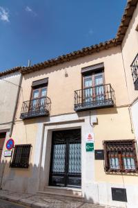 Colmenar de OrejaLa Encomienda de Oreja的街道上设有窗户和阳台的建筑