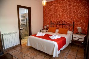 Colmenar de OrejaLa Encomienda de Oreja的一间卧室配有一张带橙色枕头的大床