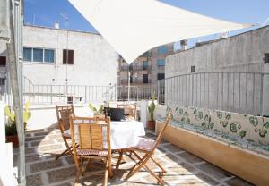 奥斯图尼Casa Zefiro - The Fab Stay的阳台的天井配有桌椅