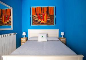 奥斯图尼Casa Zefiro - The Fab Stay的一间卧室配有一张蓝色墙壁的床