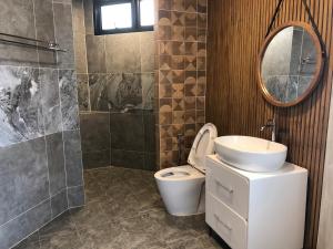 班佩Likita Resort的一间带卫生间、水槽和镜子的浴室