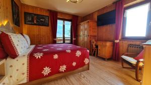 查兰德圣安塞尔Casa Margherita Chambres d'Hôtes & SPA的一间卧室配有一张带雪花的红色毯子的床