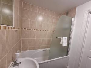 布里斯托Stockwood Apartment by Cliftonvalley Apartments的带淋浴、盥洗盆和浴缸的浴室
