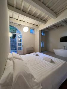 乌尔比诺Urbino Apartment - Torricini View的卧室配有一张白色大床和浴缸