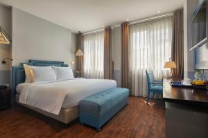 河内HANOI FLORA HOTEL的酒店客房设有一张大床和一张书桌。