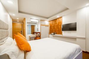 加德满都Durbar Hotel & Residence的一间带白色床的卧室和一间厨房