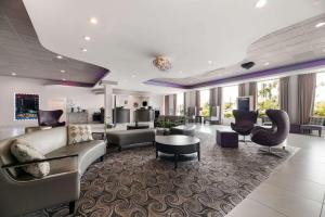 奥兰多Clarion Inn & Suites Across From Universal Orlando Resort的客厅配有沙发和椅子