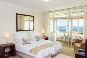 开普敦Villa Marina Guest House的一间带一张白色大床的卧室和一个阳台