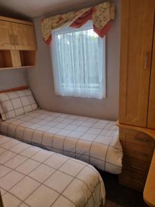 锡德卡普Quite 3 Bedroom Static Caravan的小型客房 - 带2张床和窗户