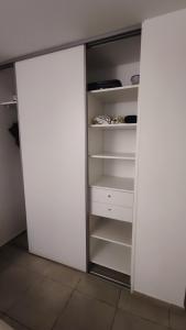 MontjolyStudio confort avec jardinet的开放式衣柜,配有白色门和架子