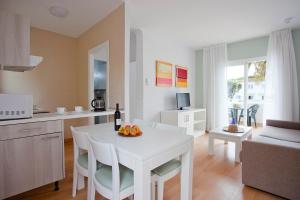 克里斯托港Apartamentos Vista Alegre Mallorca的厨房以及带白色桌椅的起居室。